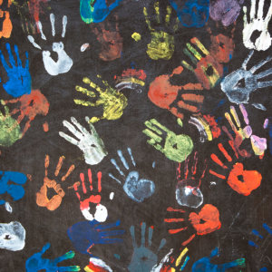 Colorful Painted Handprints on a black wall symbolizing diversity and human rights